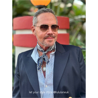 Navy silk paisley bandana worn as a neckerchief with a blue shirt and navy blazer, showcasing the scarf's elegant pattern and versatile styling