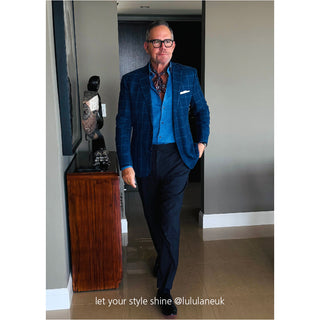 Plum purple geometric silk neckerchief styled with blue checkered blazer and vest, demonstrating sophisticated men's formal fashion accessory
