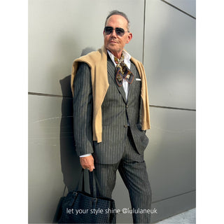 Man wearing Amazon Toucan organic cotton-silk scarf in a pinstripe suit with sunglasses — classic, refined style, standing outdoors.