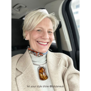 Vintage baroque silk scarf in blue and orange worn as a stylish neckerchief with cream turtleneck and herringbone blazer, showcasing elegant pattern