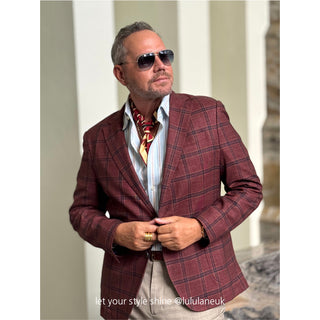 Stylish man wearing burgundy plaid blazer with red and gold Kanagawa wave silk neckerchief, white shirt, and sunglasses for elegant formal look
