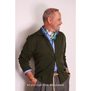 Teal green floral silk scarf elegantly styled with dark green cardigan and blue striped shirt, showcasing versatile unisex accessory wear