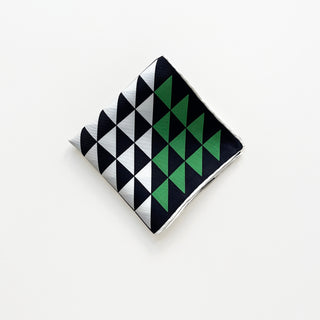 Folded geometric silk bandana in black, white, and green with modern triangle pattern.