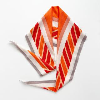 Diamond-shaped silk cashmere wool scarf in orange, red, taupe, and cream with bold geometric stripes.