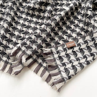 Close-up of a marled grey pure cashmere scarf with houndstooth check pattern and LuluLane label