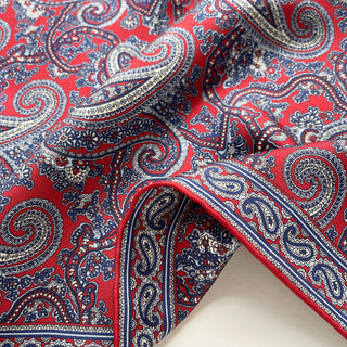 Close-up of red paisley silk neckerchief showing smooth twill texture and fine hand-rolled edges.