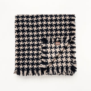 Folded pure cashmere scarf in black and beige with houndstooth check pattern on a light grey background