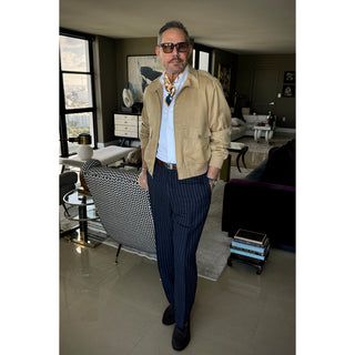 Man wearing squash yellow and navy geometric silk neckerchief with beige jacket and white shirt, elegant modern menswear style