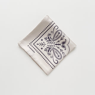 Folded ivory silk bandana scarf, 65cm square with modern paisley design and hand-rolled hems by LuluLane.