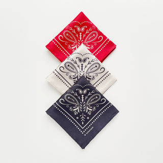Three folded bandanas in red, ivory, and charcoal grey with intricate paisley patterns by LuluLane on a light grey background.