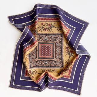 Indigo silk neckerchief with vintage floral design featuring gold center with red flowers, ornate geometric patterns, and hand-rolled purple border