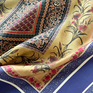 Indigo Royal Vintage Bloom silk scarf featuring intricate floral patterns with gold, burgundy and blue geometric borders on a rich silk fabric