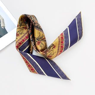 Indigo Royal Vintage Bloom silk scarf with gold background, featuring floral motifs, red accents, and distinctive diagonal indigo stripes with hand-rolled edges