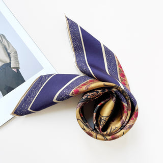 Indigo Royal silk scarf with vintage floral pattern, featuring rich purple stripes, gold borders, and intricate red botanical detailing, elegantly folded