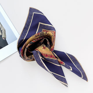 Indigo silk neckerchief with gold border and intricate floral pattern, elegantly draped to display vintage-inspired design and hand-rolled edges