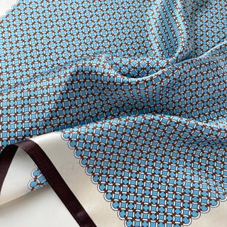 Sky blue silk bandana scarf with brown lattice pattern, featuring delicate geometric design and smooth, flowing fabric with brown edge trim
