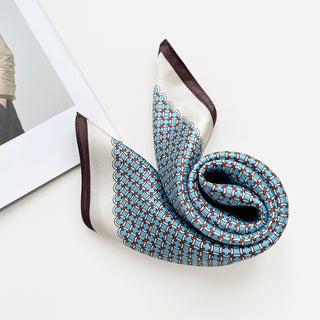 Luxury silk bandana scarf featuring sky blue lattice pattern with brown accents and edges, displayed in an elegant fold showing its smooth texture and sheen.