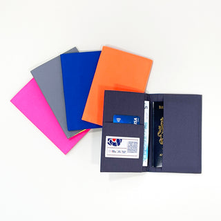 Eco-friendly recycled passport holders in pink, gray, blue, and orange, with one open navy holder showing passport, cards, and cash storage compartments