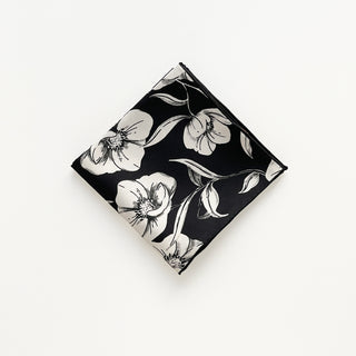 Folded women’s 65cm silk square scarf with off white poppy blossom floral print in black background, double-sided silk twill and hand-rolled hems by LuluLane