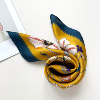 Lustrous mustard yellow silk bandana with navy border, featuring elegant floral and butterfly print in white, purple and coral tones