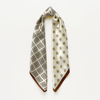 Beige silk scarf by LuluLane with intricate black paisley pattern on one side, solid cream colour on the other, featuring elegant brown border trim