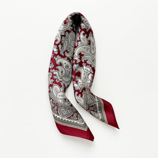 Dark red silk square neckerchief by LuluLane featuring intricate beige paisley patterns and geometric border details on a white background