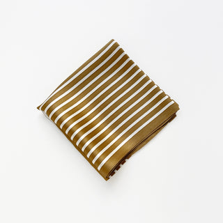 Folded silk bandana scarf featuring bronze and white striped pattern on luxurious fabric, displayed on white background