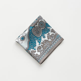 Folded silk scarf featuring turquoise blue, white and taupe baroque pattern with ornate medallions and decorative border