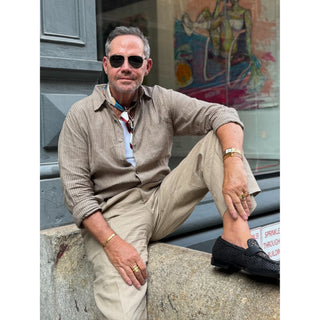 Man wearing a burgundy Bauhaus silk neckerchief with a striped linen shirt, styled as a timeless men's smart casual accessory.