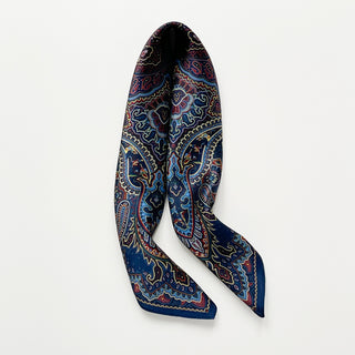 Navy blue men's neckerchief with intricate burgundy paisley pattern, elegantly draped to showcase its lustrous finish and bohemian design.