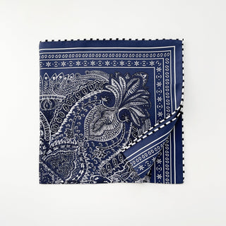 Navy silk scarf with white intricate paisley pattern and decorative border featuring hand-rolled edges with striped detail, displayed flat square