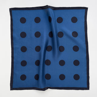 Yale blue silk scarf with classic black polka dot pattern and hand-rolled navy border, displayed flat showing elegant square bandana design
