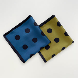 Two luxury silk scarves with polka dot pattern - olive green and Yale blue with black borders and hand-rolled edges, displayed flat against white background.