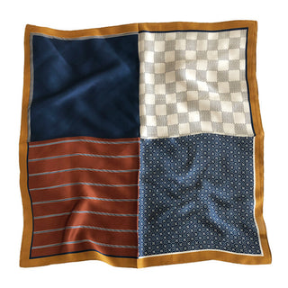 Navy geometric silk neckerchief featuring four distinct quadrants with checkerboard, solid blue, striped rust, and dotted blue patterns, bordered by gold trim.