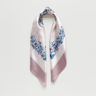 Blush pink silk scarf with elegant blue and burgundy floral leaf pattern border, showcasing lustrous fabric texture and delicate design details.