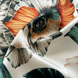 close-up of floral silk scarf with hand-drawn botanical flowers in peach ivory and teal on silk fabric