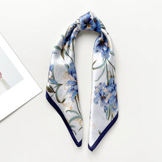 Elegant silk bandana scarf with blue bell flower pattern on white background, featuring navy blue trim and delicate green stems