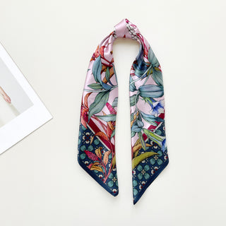 Luxury silk bandana scarf with pink background featuring botanical floral print in green, blue, and coral tones with decorative navy border