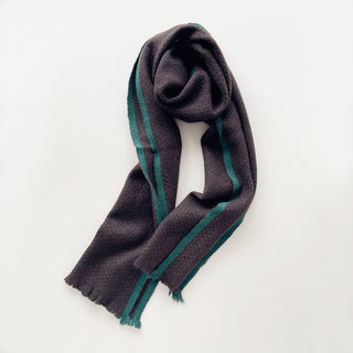 Dark chocolate brown and teal green unisex cashmere scarf arranged to show its long, compact shape.