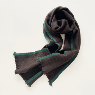 Dark chocolate brown and teal green unisex cashmere scarf arranged to show its long, compact shape.