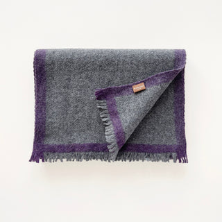 Folded heather grey cashmere scarf with a purple contrast border and short fringed ends.