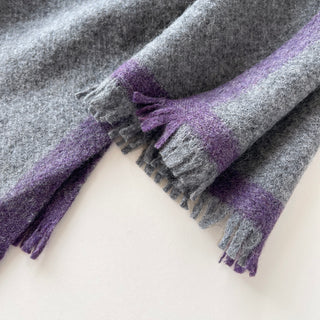 Close-up of the grey and purple short fringed ends on a 100% cashmere scarf.