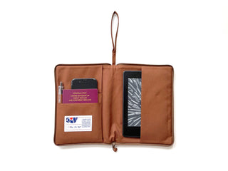 Open recycled Kindle case in terracotta brown with zippered design, showcasing multiple compartments for a Kindle device, passport, phone, and pen
