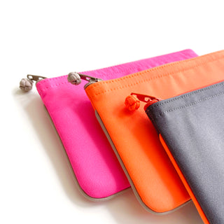 Three eco-friendly RPET zipper wallets in bright pink, orange, and grey, featuring handcrafted button pulls and neat piping edges
