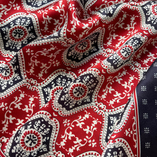 Luxurious red and navy silk scarf with geometric floral pattern, featuring white ornamental details and a silky, flowing texture