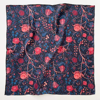 Square silk scarf with navy blue background featuring intricate red and pink floral pattern with hand-rolled edges displaying lustrous silk twill texture
