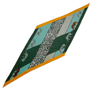 Diamond-shaped cashmere silk scarf in cool palette with green, turquoise, and mustard tones featuring leopard print pattern and cheetah silhouette accents