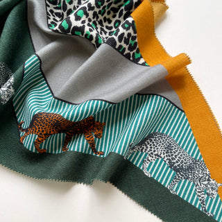 Luxurious cashmere silk scarf with cool palette featuring green, gray, and mustard tones, decorated with leopard print patterns and striped details