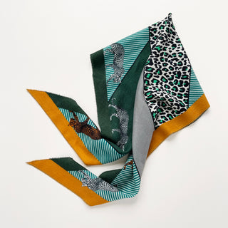 Diamond-shaped cashmere silk scarf featuring green leopard print pattern, turquoise striped sections, mustard border, and gray accent on white background