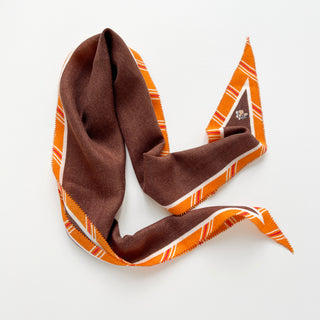 Diamond-shaped brown cashmere silk scarf with orange plaid edging in a classic English pattern, displayed elegantly against white background
